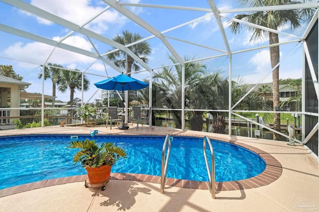 view of swimming pool featuring glass enclosure and a patio