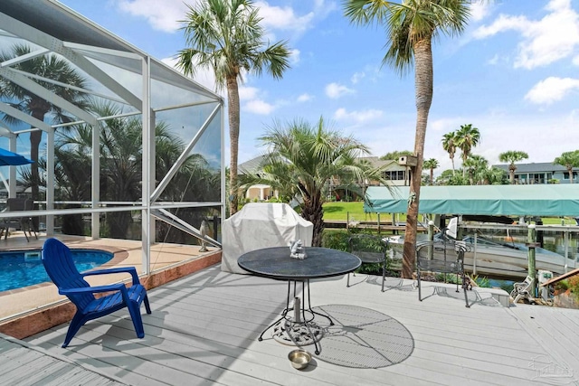 1129 Seabreeze Ln, Gulf Breeze, FL 32563 - wooden terrace with area for grilling, an outdoor pool, a dock, and glass enclosure