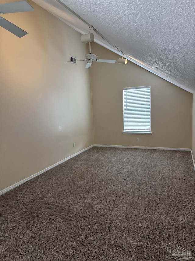 additional living space with visible vents, a textured ceiling, lofted ceiling, and a ceiling fan