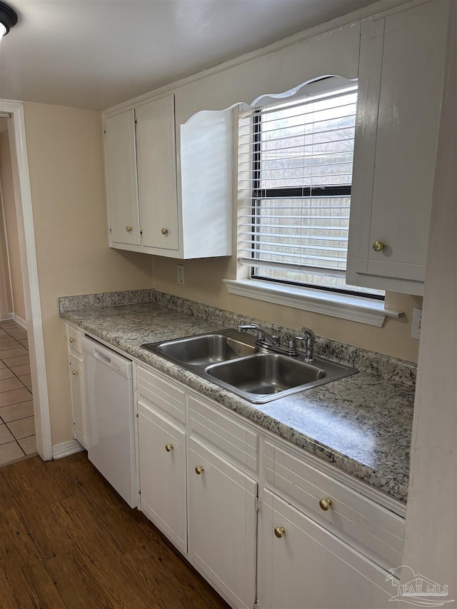 kitchen with a sink, white cabinetry, white dishwasher, light countertops, and dark wood-style flooring