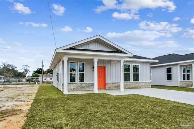 view of front of home with brick siding, board and batten siding, and a front lawn