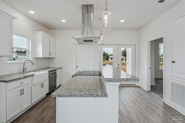 kitchen featuring stainless steel dishwasher, wood-type flooring, light stone countertops, a kitchen island, and island range hood