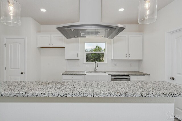 kitchen featuring hanging light fixtures, island exhaust hood, white cabinetry, and decorative backsplash