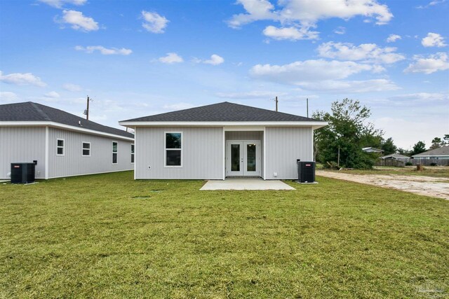 rear view of house featuring central air condition unit, french doors, and a yard