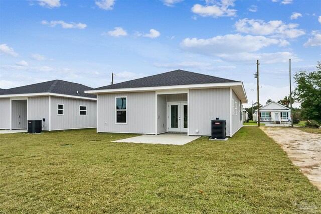 rear view of house with central air condition unit, french doors, and a yard