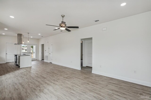 unfurnished living room with light wood-type flooring and ceiling fan