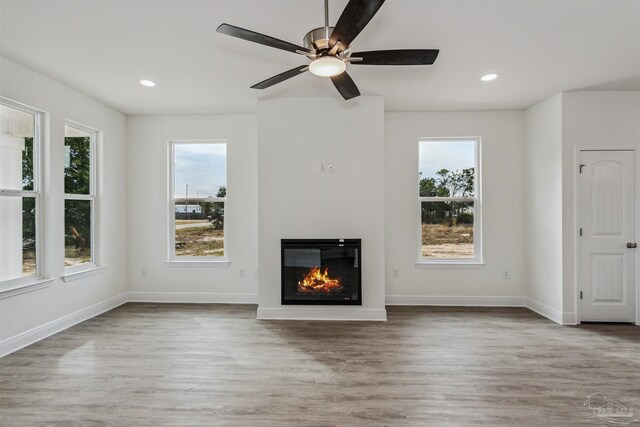 unfurnished living room with ceiling fan and hardwood / wood-style floors