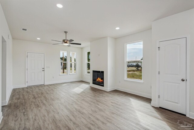 unfurnished living room featuring ceiling fan and hardwood / wood-style flooring