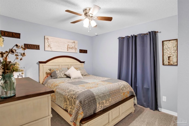 carpeted bedroom featuring ceiling fan and a textured ceiling