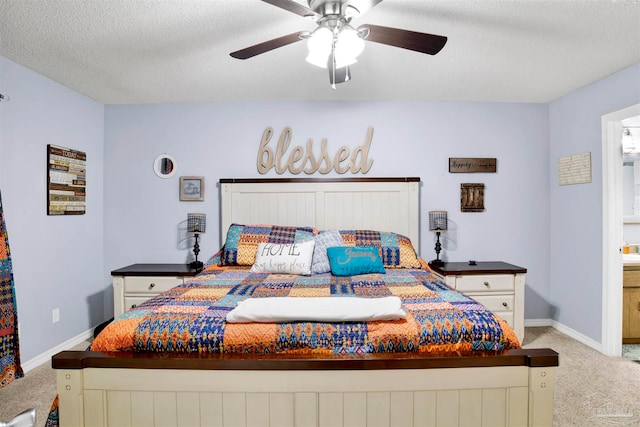 bedroom with ceiling fan, light colored carpet, and a textured ceiling