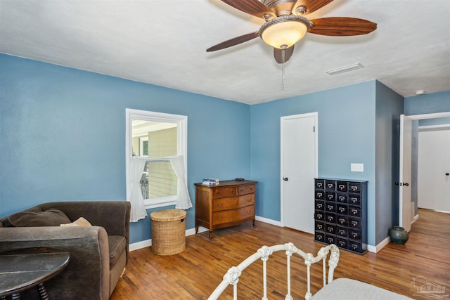 living area featuring wood-type flooring and ceiling fan