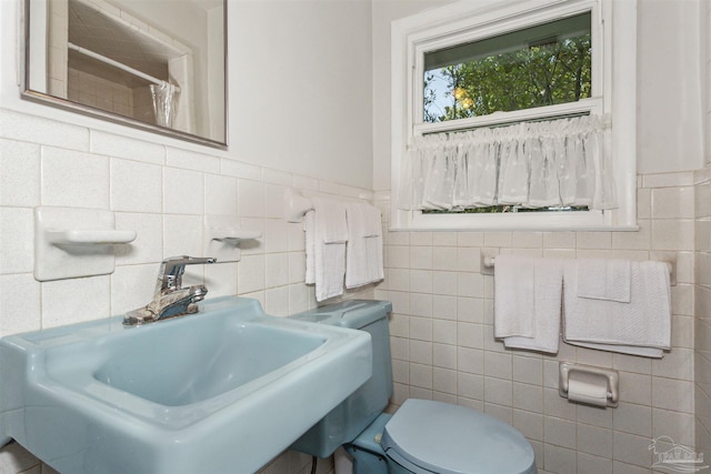 bathroom with a shower with curtain, sink, tile walls, and toilet