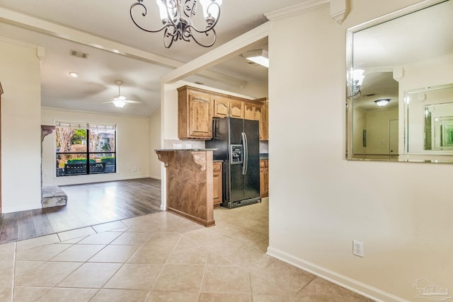 kitchen featuring light tile patterned flooring, black fridge with ice dispenser, ornamental molding, kitchen peninsula, and ceiling fan with notable chandelier