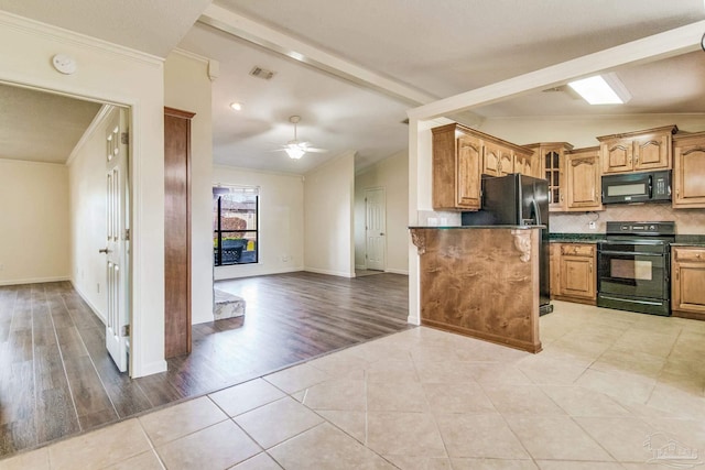 kitchen with light tile patterned floors, crown molding, tasteful backsplash, lofted ceiling with beams, and black appliances