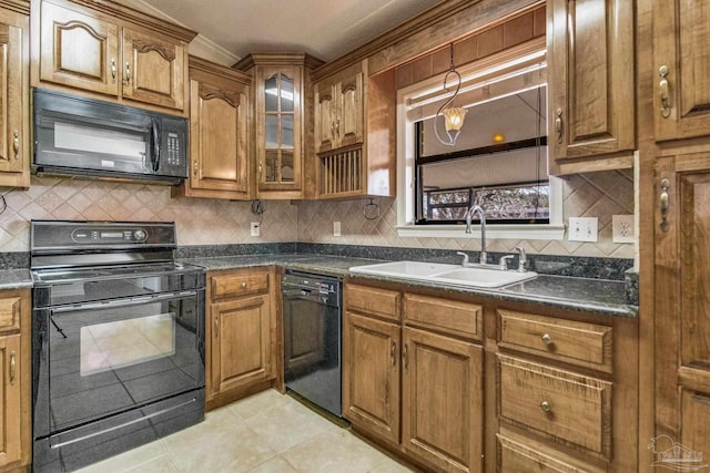 kitchen with tasteful backsplash, sink, dark stone counters, light tile patterned floors, and black appliances