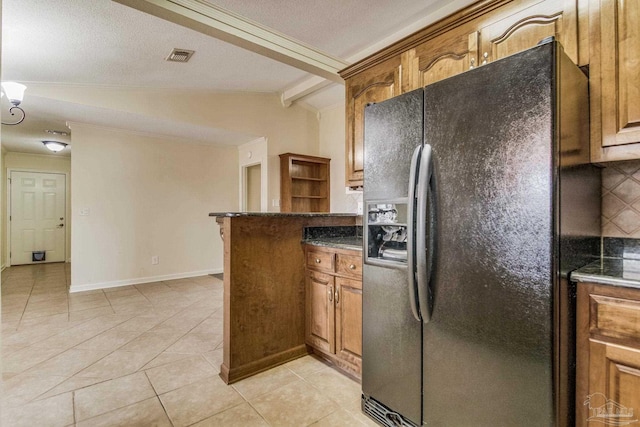 kitchen with light tile patterned flooring, lofted ceiling with beams, backsplash, black fridge with ice dispenser, and kitchen peninsula