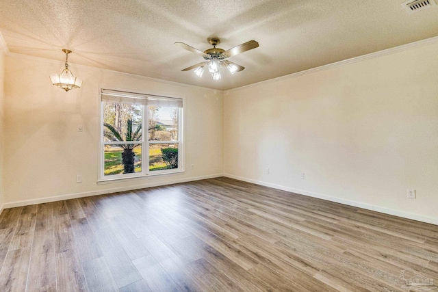 empty room featuring crown molding, ceiling fan with notable chandelier, hardwood / wood-style floors, and a textured ceiling