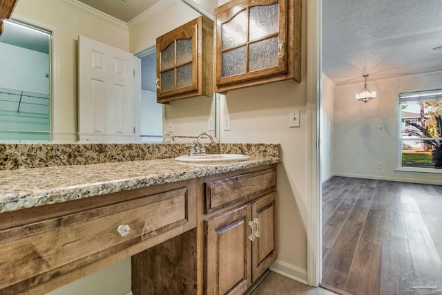 bathroom featuring crown molding, vanity, hardwood / wood-style floors, and a textured ceiling