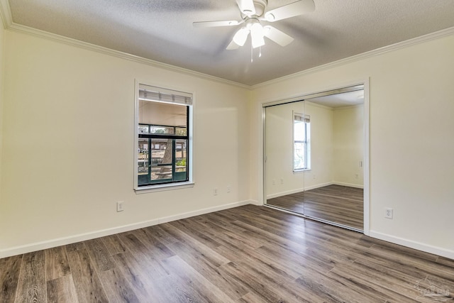 unfurnished room featuring hardwood / wood-style flooring, ornamental molding, and a textured ceiling