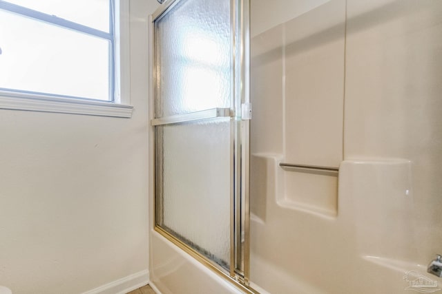 bathroom featuring combined bath / shower with glass door