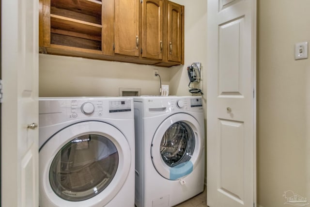 washroom featuring washer and dryer and cabinets