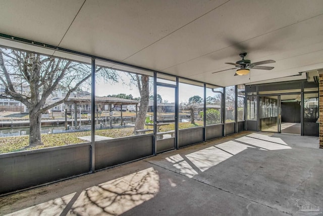 unfurnished sunroom with a water view and ceiling fan