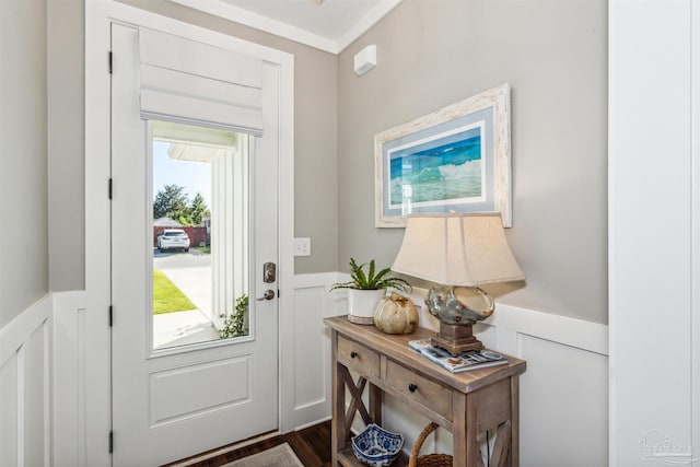 doorway featuring dark wood-type flooring and ornamental molding