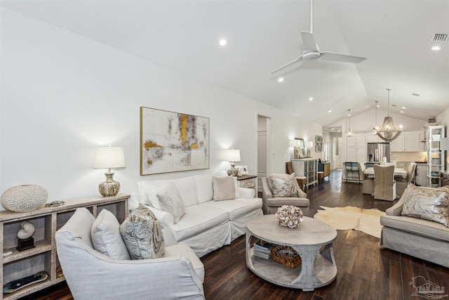 living room featuring dark hardwood / wood-style floors, ceiling fan with notable chandelier, and vaulted ceiling