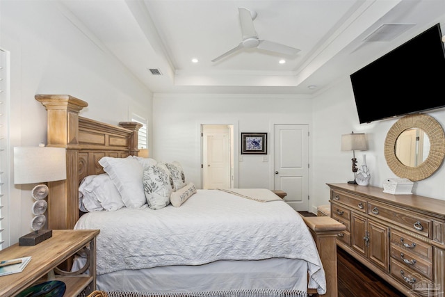 bedroom with ceiling fan, dark hardwood / wood-style floors, and a raised ceiling