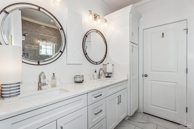 bathroom with a tile shower and vanity