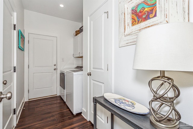 clothes washing area featuring washer and clothes dryer and dark hardwood / wood-style flooring