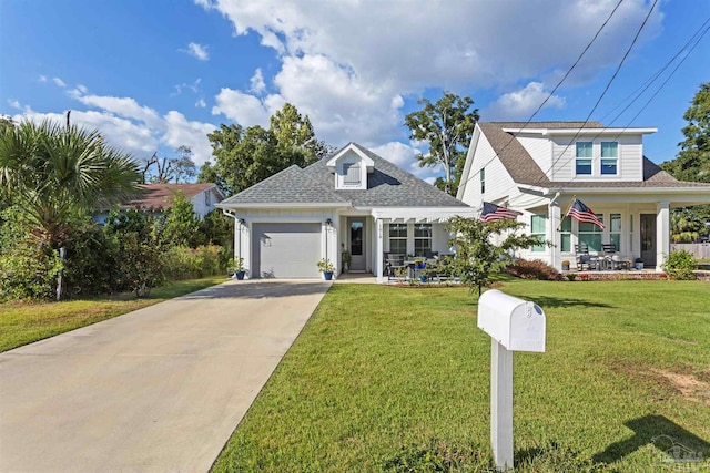 view of front of property featuring a porch, a front lawn, and a garage