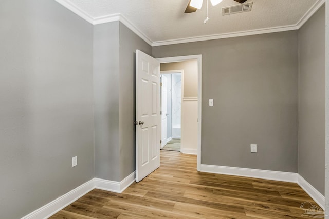 unfurnished room with ceiling fan, a textured ceiling, light hardwood / wood-style floors, and ornamental molding