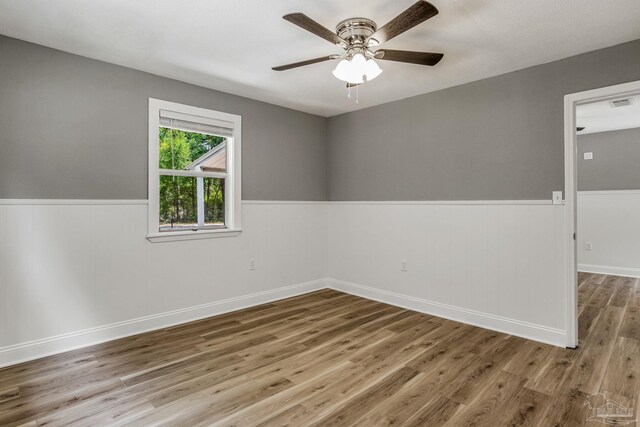 empty room with hardwood / wood-style flooring and ceiling fan