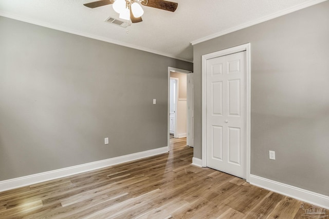 empty room featuring ceiling fan, light wood-type flooring, and ornamental molding