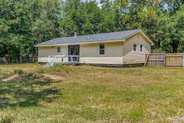 back of property with a yard and a deck