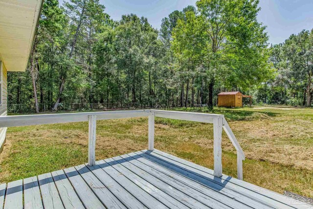 wooden deck featuring a yard and a shed