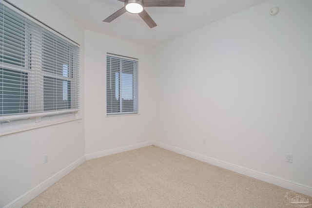 unfurnished room with ceiling fan and carpet