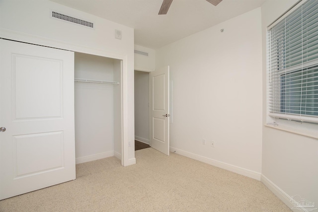 unfurnished bedroom with light colored carpet, ceiling fan, and a closet