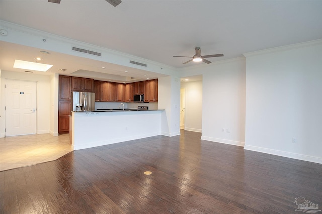 unfurnished living room featuring wood-type flooring, ornamental molding, and ceiling fan