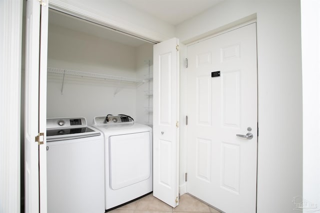 laundry room featuring washer and dryer and light tile patterned flooring