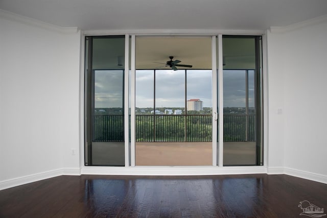 spare room featuring crown molding, ceiling fan, expansive windows, and hardwood / wood-style floors