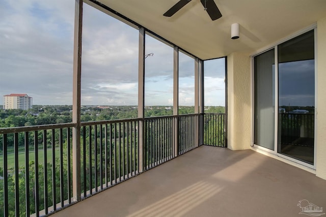 unfurnished sunroom with ceiling fan