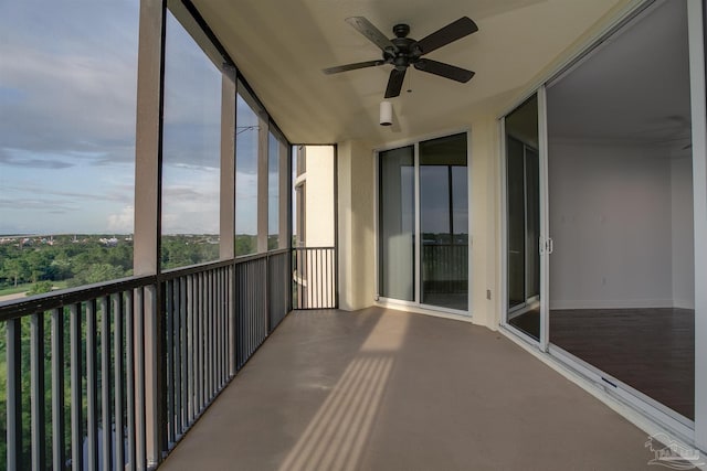 unfurnished sunroom with ceiling fan