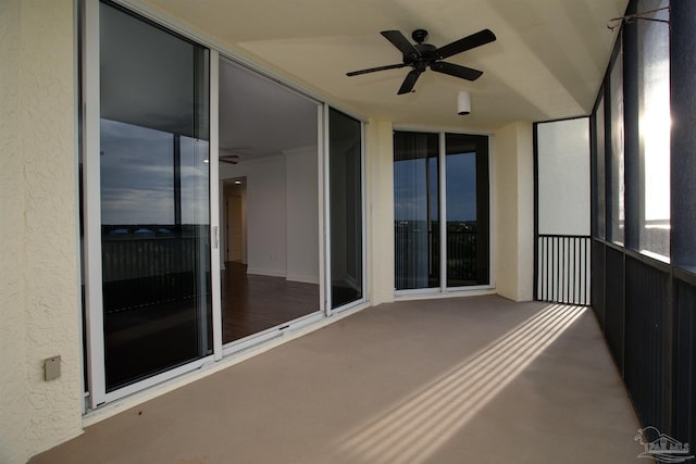 unfurnished sunroom featuring ceiling fan