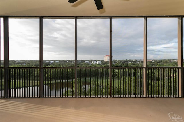 unfurnished sunroom with ceiling fan