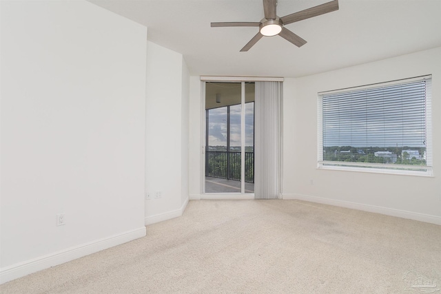 carpeted empty room with a healthy amount of sunlight and ceiling fan