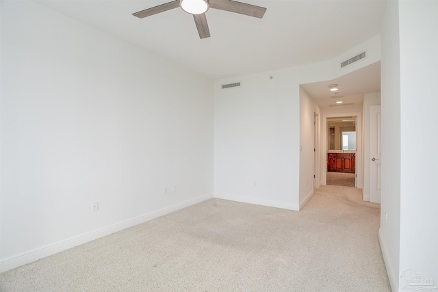 spare room featuring ceiling fan and light carpet