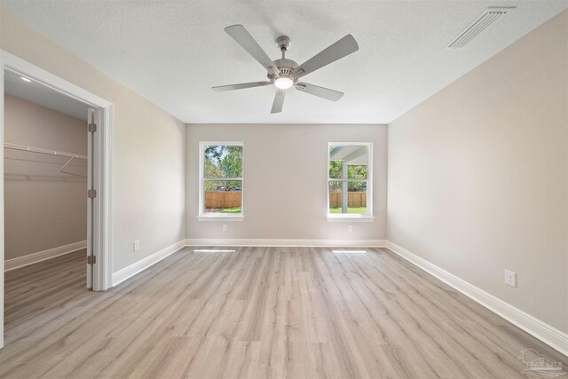 4485 Edgewood Dr, Milton, FL 32583 - unfurnished bedroom featuring light wood-style floors, baseboards, a spacious closet, a closet, and ceiling fan
