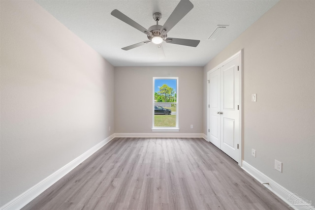 unfurnished bedroom featuring light hardwood / wood-style floors, a textured ceiling, and ceiling fan